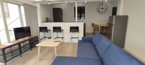 Espace de vie ouvert moderne à la Résidence des dunes à Landéda avec canapé bleu, cuisine et salle à manger