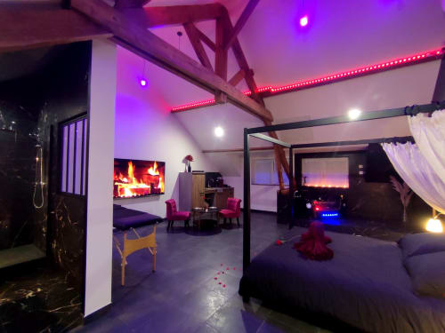 Appartement de luxe moderne Lesdoucesnuits45 à Montargis avec éclairage ambiant violet, cheminée, bain à remous et design contemporain