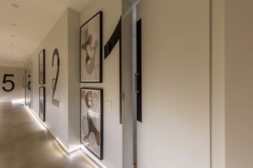 Corridoio moderno dell'hotel Casa Lounge Istria Cagliari con base illuminata, opere d'arte astratte e numeri stanza