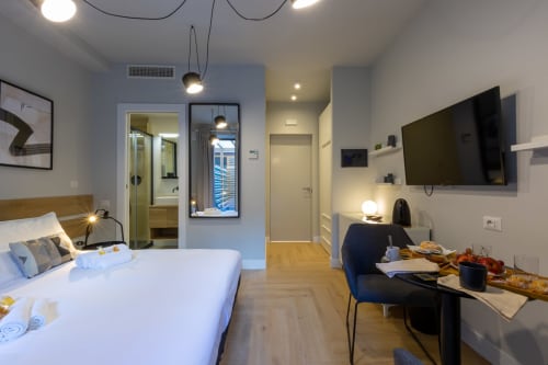 Moderna camera d'hotel presso Casa Lounge Istria a Cagliari con letto, area di lavoro, TV a schermo piatto e bagno privato con giardino