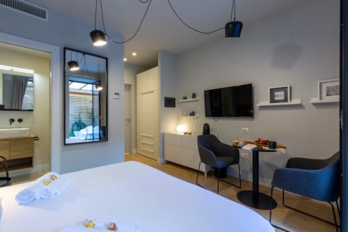 Camera moderna a Casa Lounge Istria a Cagliari con vista sul giardino, dotata di letto, TV e zona di lavoro