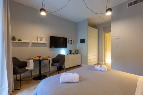 Camera moderna a Casa Lounge Istria a Cagliari con letto, zona pranzo, TV e arredamenti contemporanei