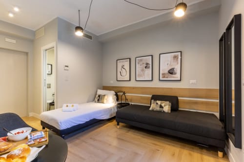 Camera moderna di Casa Lounge Istria a Cagliari con due letti, testata in legno e arredamento contemporaneo