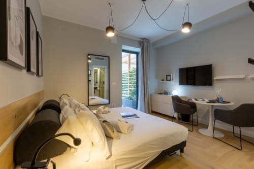 Camera moderna a Casa Lounge Istria a Cagliari con vista giardino, letto matrimoniale, scrivania, TV e illuminazione contemporanea