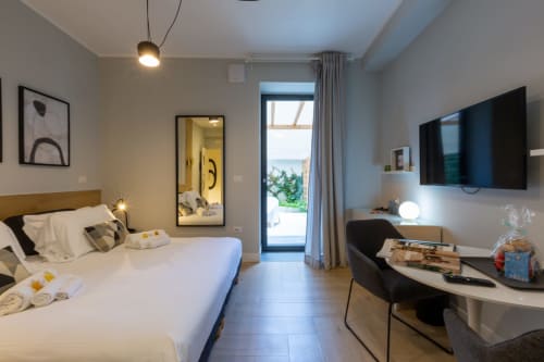 Camera moderna a Casa Lounge Istria a Cagliari con vista sul giardino, letto, TV e zona lavoro