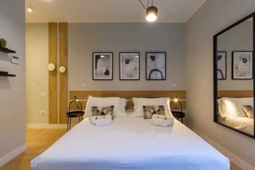 Camera moderna di Casa Lounge Istria a Cagliari con letto bianco, testata in legno e arte contemporanea