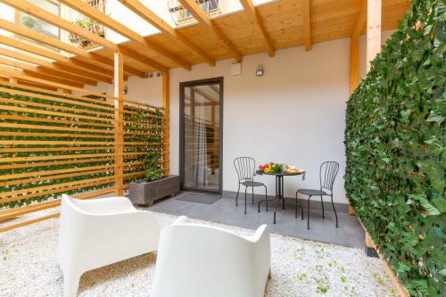 Elegante terrazza da giardino a Casa Lounge Istria Cagliari con zona pranzo, salotto relax, pergolato in legno e lussureggiante edera