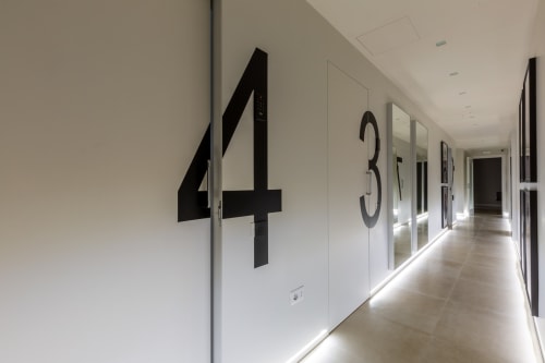 Moderno corridoio di Casa Lounge Istria a Cagliari con numeri stanze 4 e 3 su pareti bianche, design contemporaneo