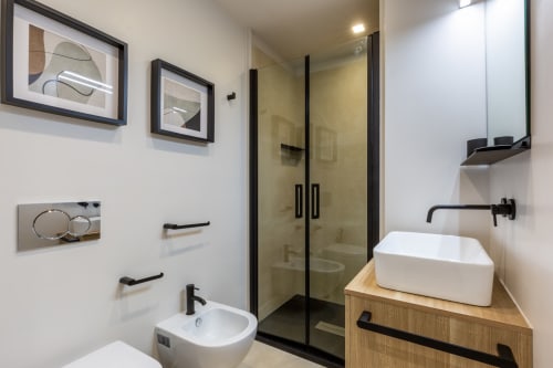 Bagno moderno di Casa Lounge Istria Cagliari con lavabo bianco, cabina doccia nera e arredi contemporanei