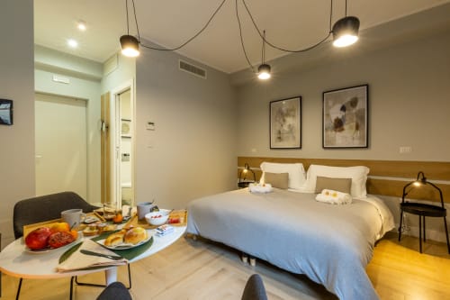 Camera moderna di Casa Lounge Istria a Cagliari con colazione, luci a sospensione e pavimento in legno