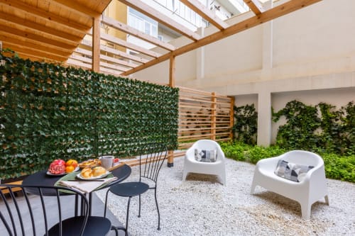 Patio moderno a Casa Lounge Istria con muri di edera, pergolato in legno, tavolo da pranzo e sedute bianche a Cagliari