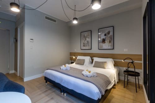 Camera moderna a Casa Lounge Istria, Cagliari BnB con letti gemelli, testata in legno, luci a sospensione e arredamento minimalista