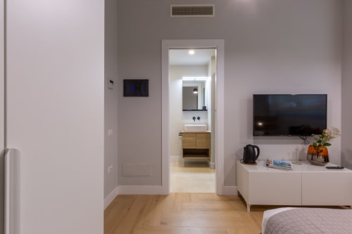 Camera moderna presso Casa Lounge Istria a Cagliari con bagno ensuite, TV a schermo piatto e arredi minimalisti