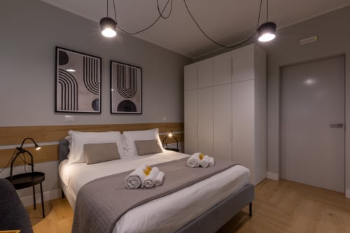 Camera moderna di Casa Lounge Istria a Cagliari con testata in legno, biancheria bianca e arredamento minimalista