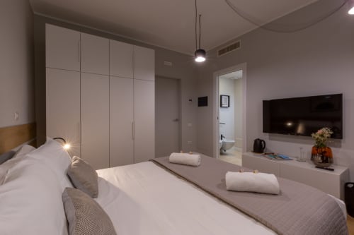 Camera moderna di Casa Lounge Istria a Cagliari con letto matrimoniale, TV a schermo piatto e vista sulla città
