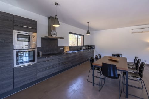 Vaste séjour avec cuisine équipée, fours, plaques à induction, table