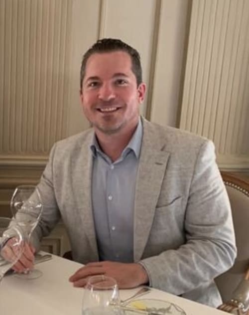 Professional manager at Manoir de la Nogrie in Val d'Izé, France, seated at dining table
