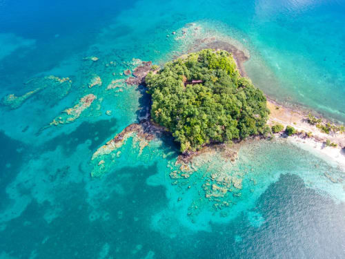 Vue aérienne d'une île forestière luxuriante entourée des eaux turquoise des Caraïbes près des Trois-Ilets, Martinique