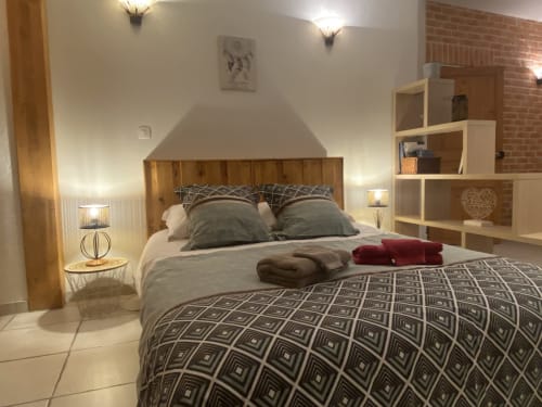 Chambre moderne du Gîte Le Cocon De Curson à Chanos-Curson avec lit en bois, parure géométrique et rangement blanc