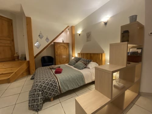 Chambre douillette sous les combles du B&B Le Cocon De Curson à Chanos-Curson avec mobilier en bois et plafond mansardé