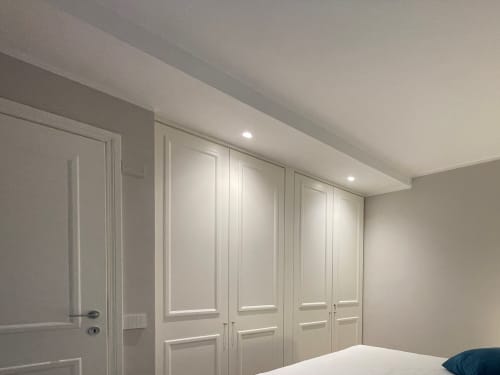 Modern bedroom with built-in white wardrobe and recessed lighting at Covo del Pirata apartment, Venice