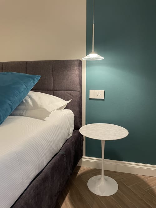 Modern bedroom in Covo del Pirata Venice apartment with teal accent wall, dark headboard, white bedding, and minimalist