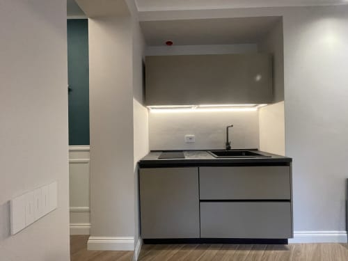 Modern kitchenette in Apartment Edward at Covo del Pirata, Venice, with black countertop, sink, cooktop and under-cabinet