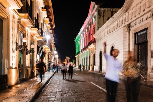 people walking on the streets of merida at night