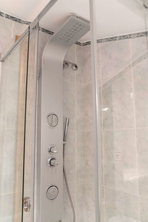 Moderno box de ducha con múltiples salidas y alcachofa de lluvia en el hotel Casa Rural Las Cuevas De Setenil