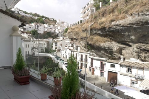 Vista de la terraza del pueblo blanco de Setenil de las Bodegas, acurrucado contra el acantilado dramático, Casa Rural Las Cuevas de Setenil
