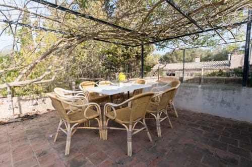Sa Casa Rotja | Sineu, España -Este apartamento es el más grande, ideal para grupos de amigos, una gran família o dos famílias. Tiene una gran sala comedor con chimenea en la planta de abajo. Con una gran mesa para 8 personas o más. Además dispone de sofás y butacas para descansar. En la planta superior está la cocina con todo lo necesario para cocinar y comer, la terraza privada con vistas al patio, el baño completo y las tres habitaciones. En cada habitación hay dos camas individuales.