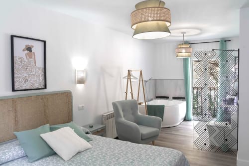 Dormitorio moderno en Casa Rural Las Cuevas De Setenil con cabecero de ratán, baño privado y diseño contemporáneo