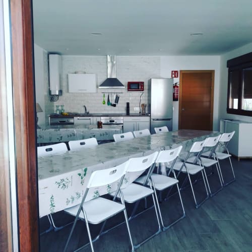 Cuisine et salle à manger modernes aux chaises blanches du gîte Casa Rural La Perla à Hiendelaencina, Espagne