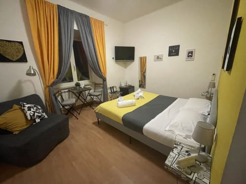 Stanza gialla con letto, divano, scrivania e vista sulla città presso AD Trastevere Guest House a Roma