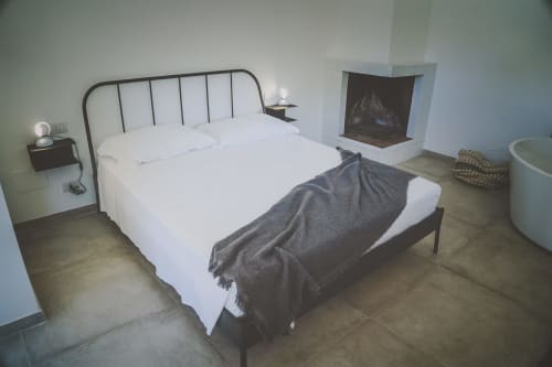 Camera moderna a Casa Ziazì a Monopoli con letto in metallo, biancheria bianca, camino e arredi contemporanei