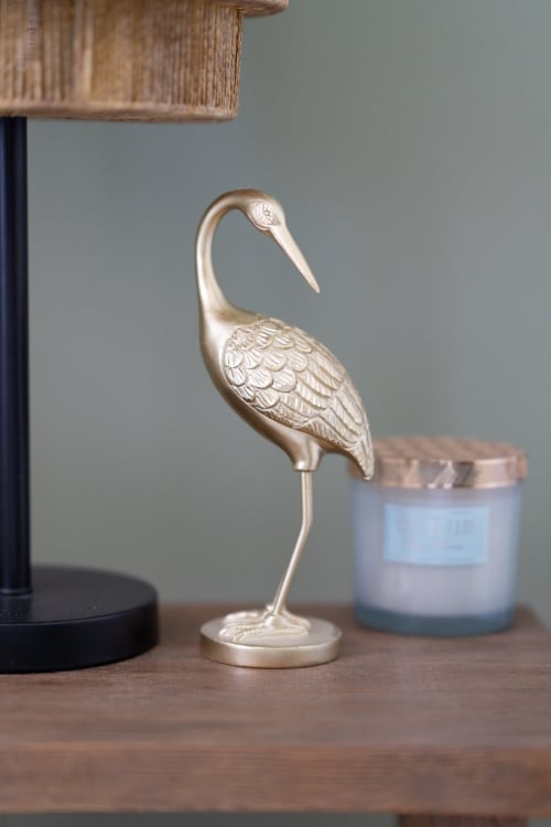 Statuette de grue dorée sur surface en bois au Pavillon Des Millésimes & SPA, Lussac