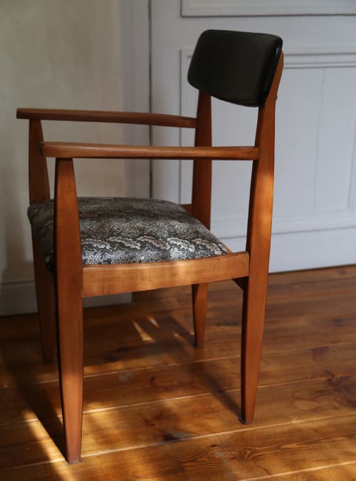 Mid-century wooden armchair with black headrest and patterned upholstered seat at Le Grand Duc boutique hotel in