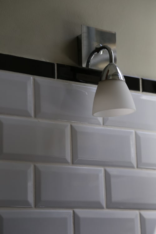 Applique murale moderne au-dessus du carrelage blanc métro à l'hôtel Le Grand Duc, Valenciennes