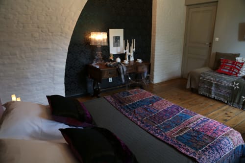 Chambre au Le Grand Duc B&B à Valenciennes avec lit, cheminée, tapis orné et mur d'accent foncé