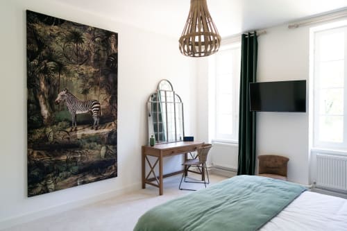 An elegant room at the Pavillon Des Millésimes featuring a wooden headboard, a palette of greens, a green armchair, and views of the pool and landscaped garden