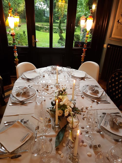 Elegant dining table setup at Le Grand Duc B&B in Valenciennes with place settings, candlelight, and floral centerpiece.