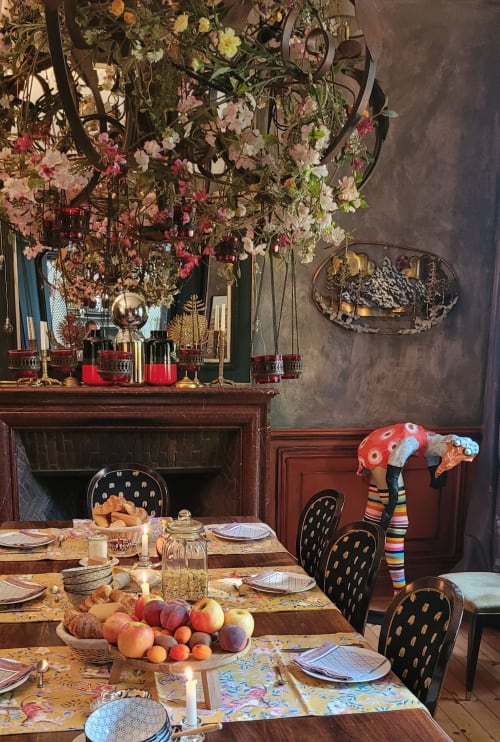 Salle à manger élégante du B&B Le Grand Duc à Valenciennes avec arrangements floraux, cheminée et table garnie de fruits