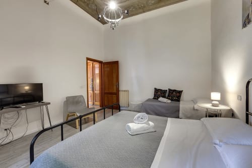Bright Florence apartment with two beds, TV, wooden doors, and modern furnishings at Sleep Tight BnB