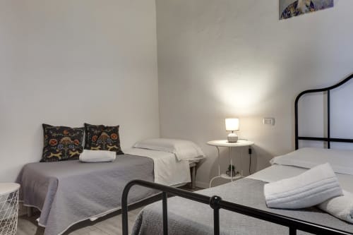 Modern bedroom in Sleep tight Florence apartment with twin beds, black metal frames, and garden view in Firenze