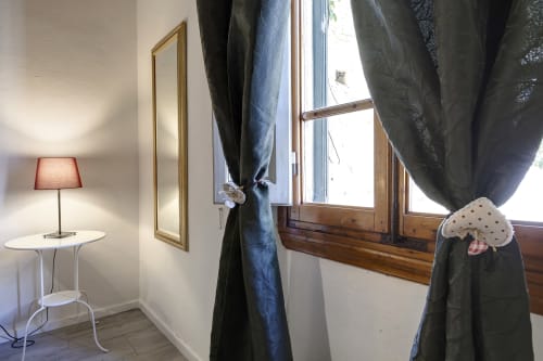 Bright apartment interior at Sleep tight Florence with dark curtains, wooden window frame, table lamp, and garden view
