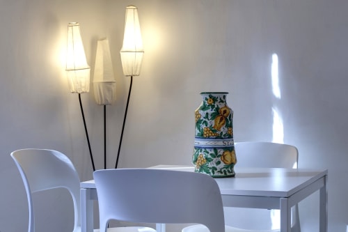 Modern dining area at Sleep tight Florence with white chairs, table, decorative ceramic vase, and contemporary floor lamps