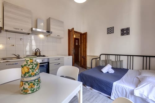 Cozy Florence apartment studio with kitchenette, dining table, and bed with garden view at Sleep tight BnB