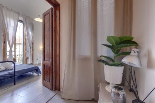 Modern Florence apartment entrance with potted plant, wooden door, and balcony access at Sleep tight B&B