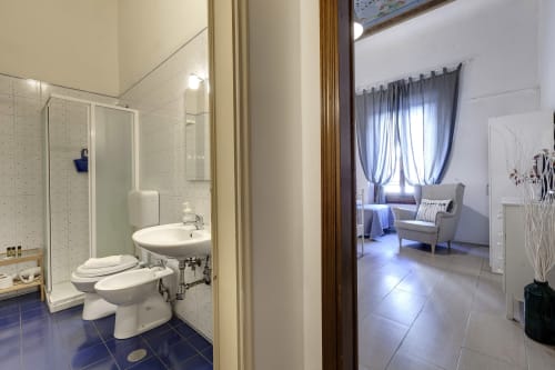 Ground floor apartment bathroom and living area at Sleep tight Florence B&B in Firenze with shower, toilet, sink, and bedroom