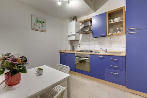 Modern kitchen in Sleep tight Florence ground floor apartment, Florence. Blue cabinetry, wooden counters, dining table, and